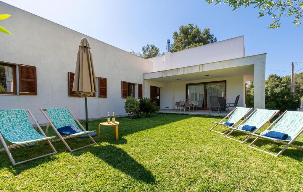 two chairs and an umbrella in the yard of a house at Amedart in Alcudia