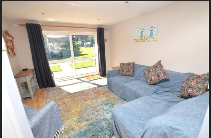 a living room with a blue couch and a window at Seabrook Lodge in Newquay