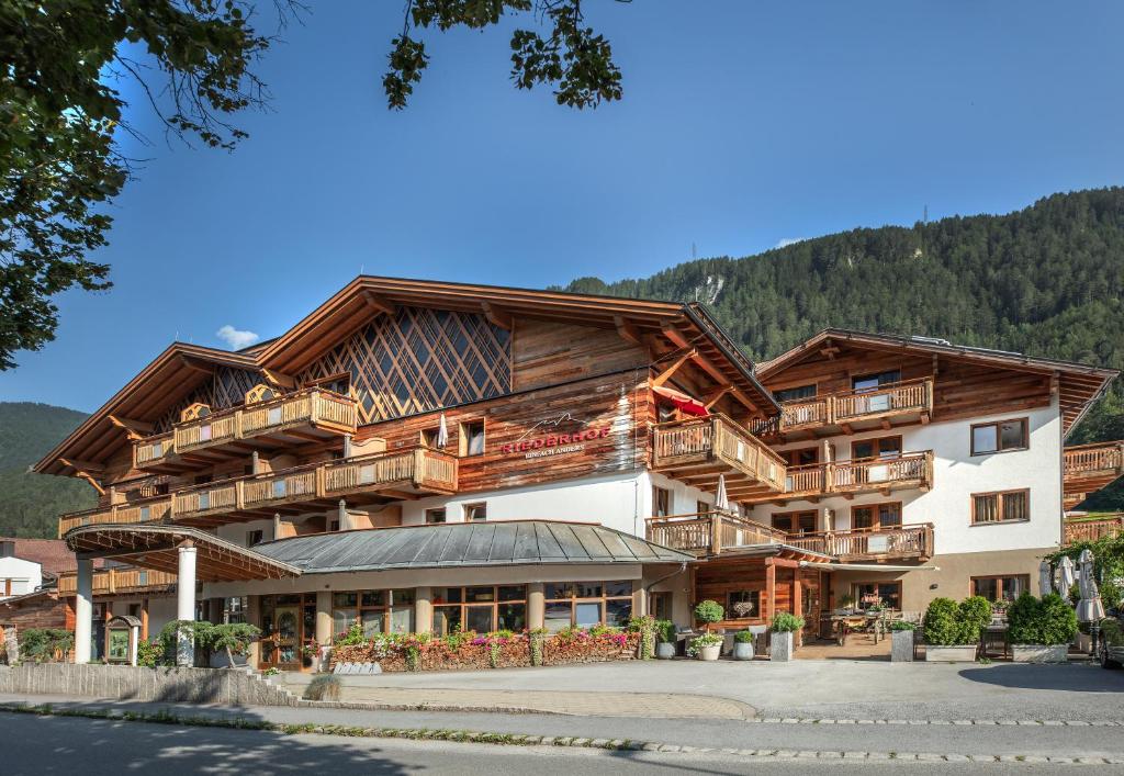 a large wooden building with a lot of balconies at Hotel Riederhof- Urlaub mit WAU! in Ried im Oberinntal