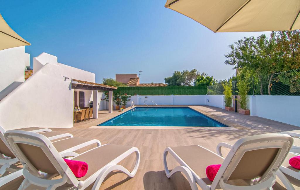 a villa with a swimming pool and lawn chairs at Murta 26 in Sa Coma