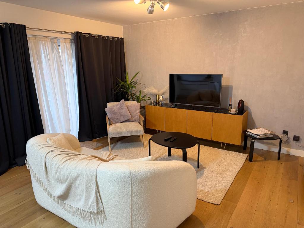 a living room with a couch and a tv at businessflat mol center in Mol