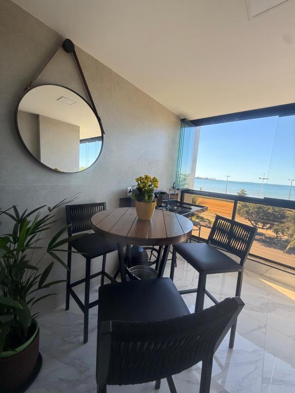 a dining room with a table and chairs and a mirror at Apartamento del sole in Vitória