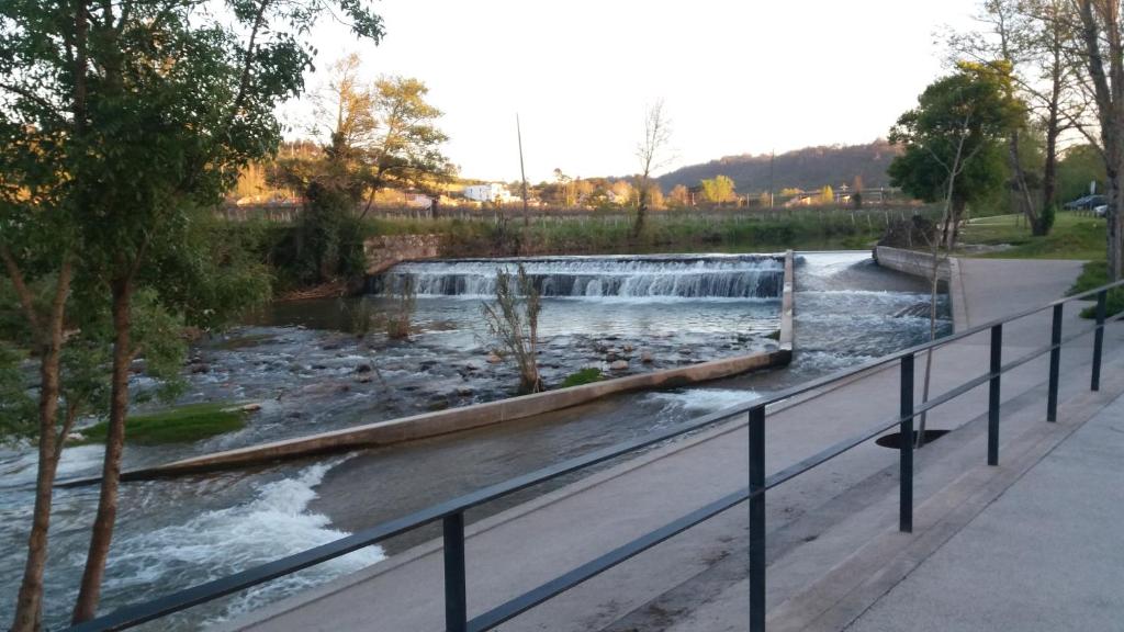 a river with a waterfall in a park at Quinta da Casinha Homestay in Pombal