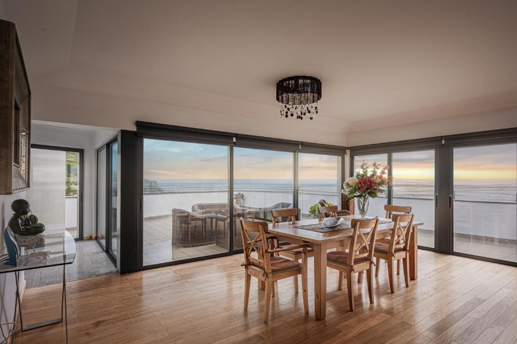 a dining room with a table and chairs at Beachfront Penthouse with Panoramic Ocean-View Terrace VIP Baia in Machico