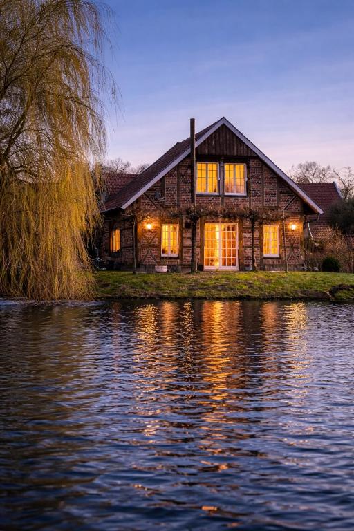 a house on the shore of a body of water at Haus am See Kamin privater Seezugang in Warendorf