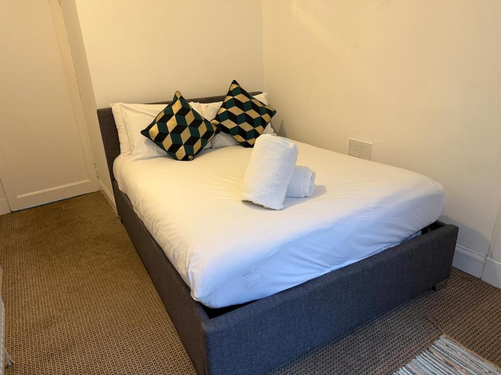 a bed with pillows and towels on top of it at Stylish Glasgow Apartment in Whiteinch