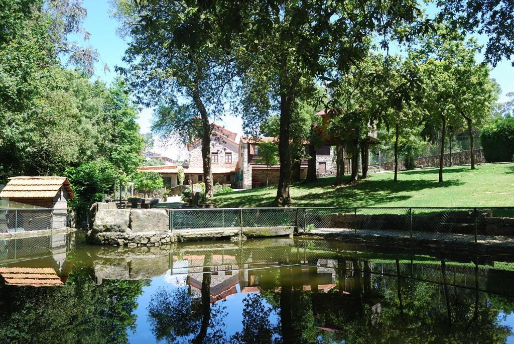 a body of water with trees and a house w obiekcie Quinta Padre Lobo w mieście Santa Maria Da Feira