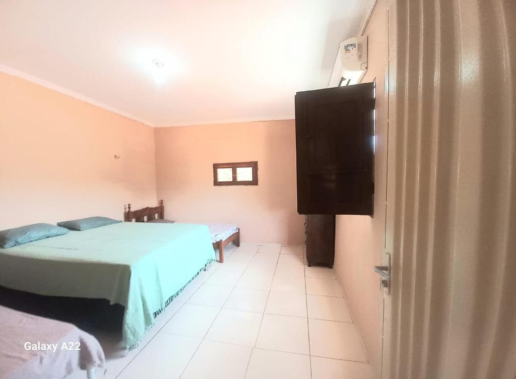 a bedroom with a bed and a flat screen tv at Apartamento Aconchegante 1 quarto in Crato