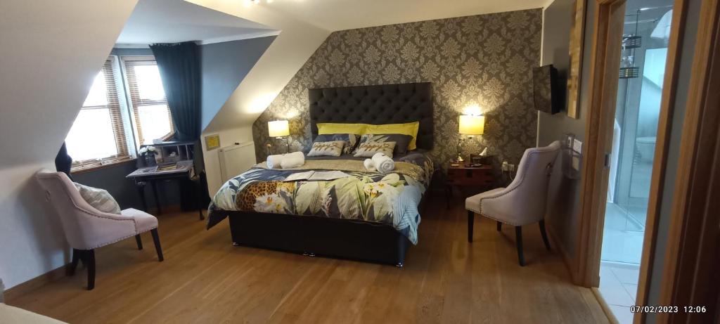 a bedroom with a bed and two chairs at Outlander Boutique B&B ONLY ADULT Suite in Cruden Bay
