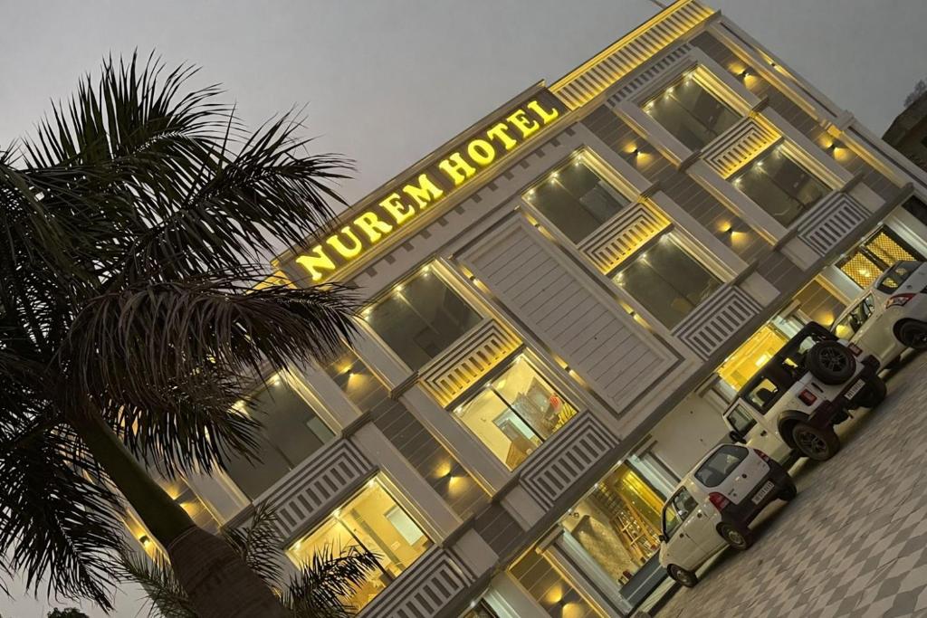 a hotel with a yellow sign on the side of a building at Nurem Hotel and Resort in Lalru