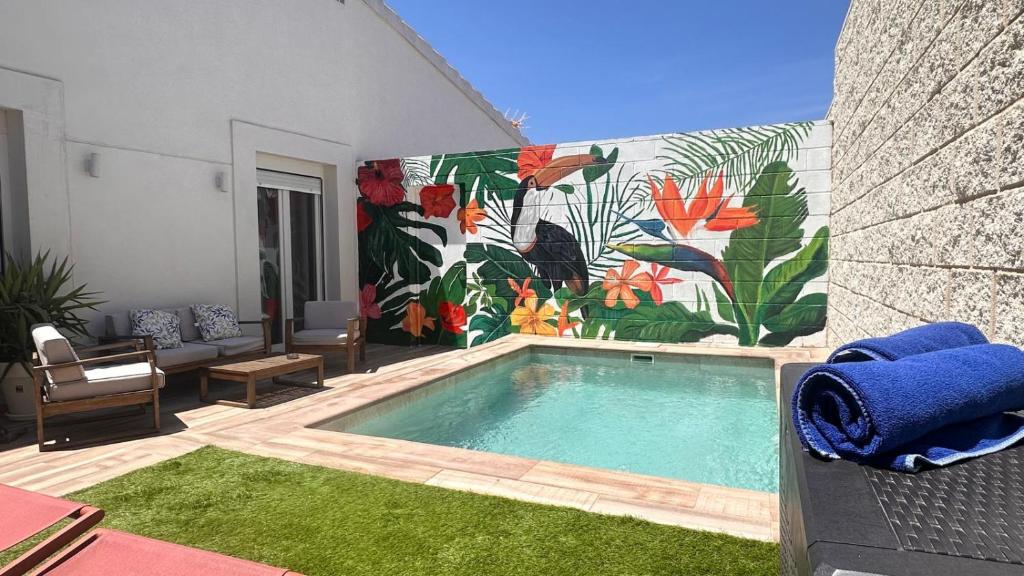 a swimming pool with a mural on the side of a building at Huellas de la Mancha in Burguillos de Toledo