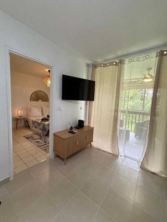 a living room with a flat screen tv on a wall at Cozy cocoon in La Madeleine in Cayenne