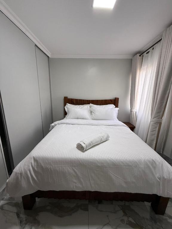 a bed with a white phone on top of it at Sage Homes in Nairobi