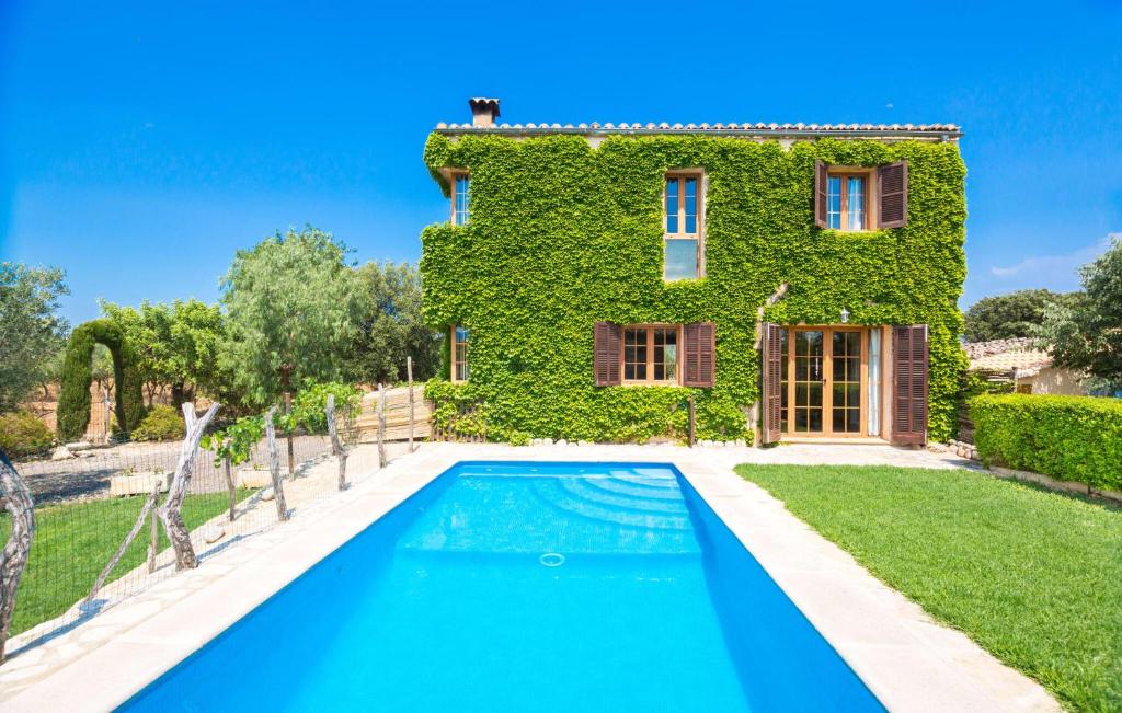 a villa with a swimming pool in front of a house at Perla Sort Llarga in Moscari
