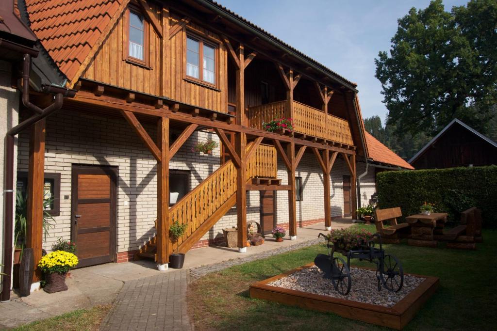 a large wooden house with a staircase and a balcony at Farma Basarovi in Prosečné