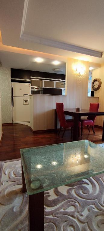 a living room with a table and a kitchen at Apartament Rycerska LUX in Łomża