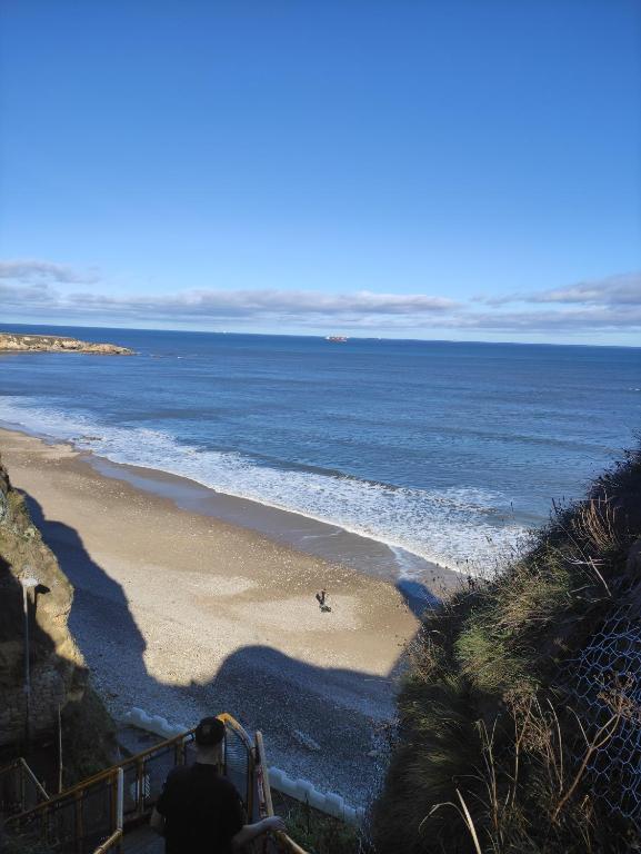 a man walking down the stairs to a beach at 3 Bedroom Apartment near the Beach in South Shields