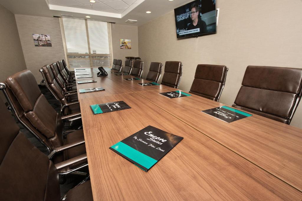 a conference room with a long table and chairs at Encore Suites by Service Plus Inns in Grande Prairie