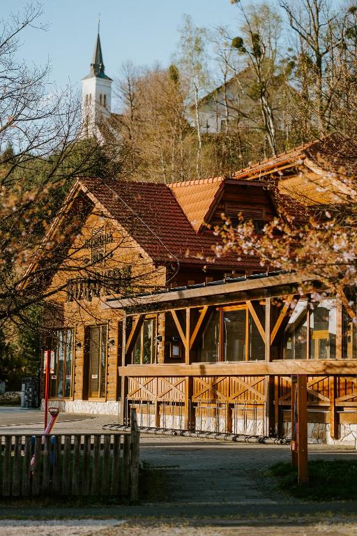 a large wooden building with a tower in the background at Ubytování pod Borovou in Malenovice