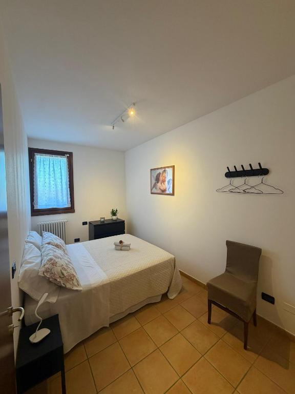 a bedroom with a bed and a chair at La Dimora dei Cri in Cona