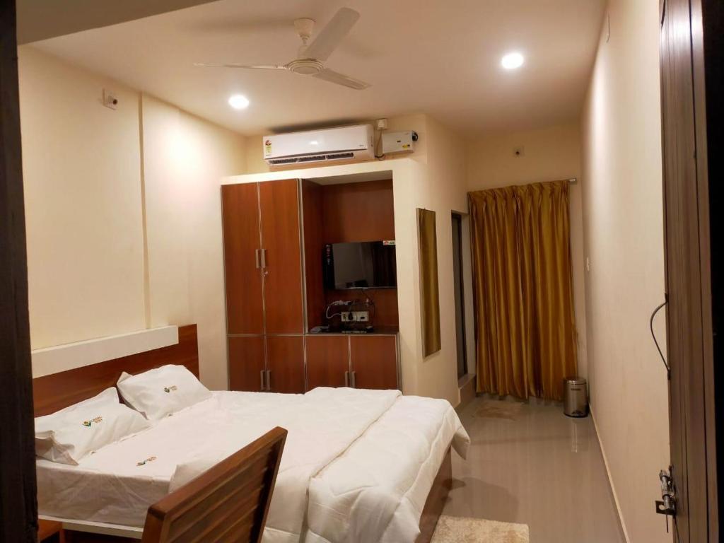 a bedroom with a large white bed and a cabinet at Casal stay in Mannārakkāt