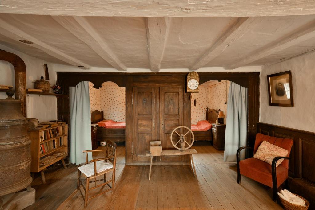 a living room with a clock on the wall at Chez Oma, La petite ferme in Weinbourg