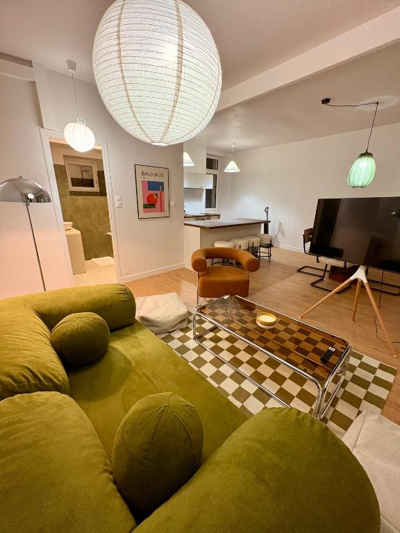 a living room with a couch and a television at Charmant T2 hyper-centre, proche gare & mer in Saint-Brieuc