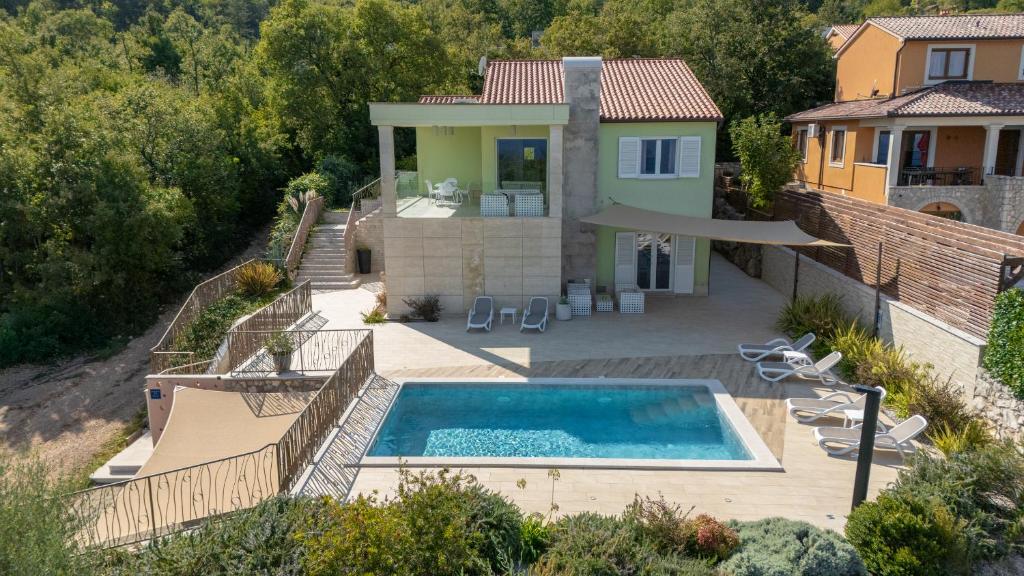 a villa with a swimming pool and a house at Villa Luce in Labin