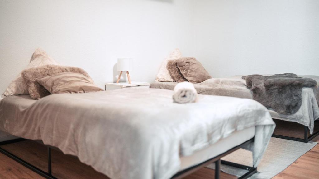 a white cat sitting on top of a bed at FlexHome Stadtnatur Ferienwohnung in Lippstadt