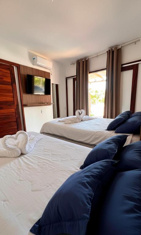 a bedroom with two beds with blue pillows at Chalé dos Anjos in Fortim