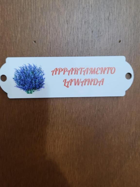 a label on a door with a blue flower on it at Casa Wanda LAWANDA in Oristano