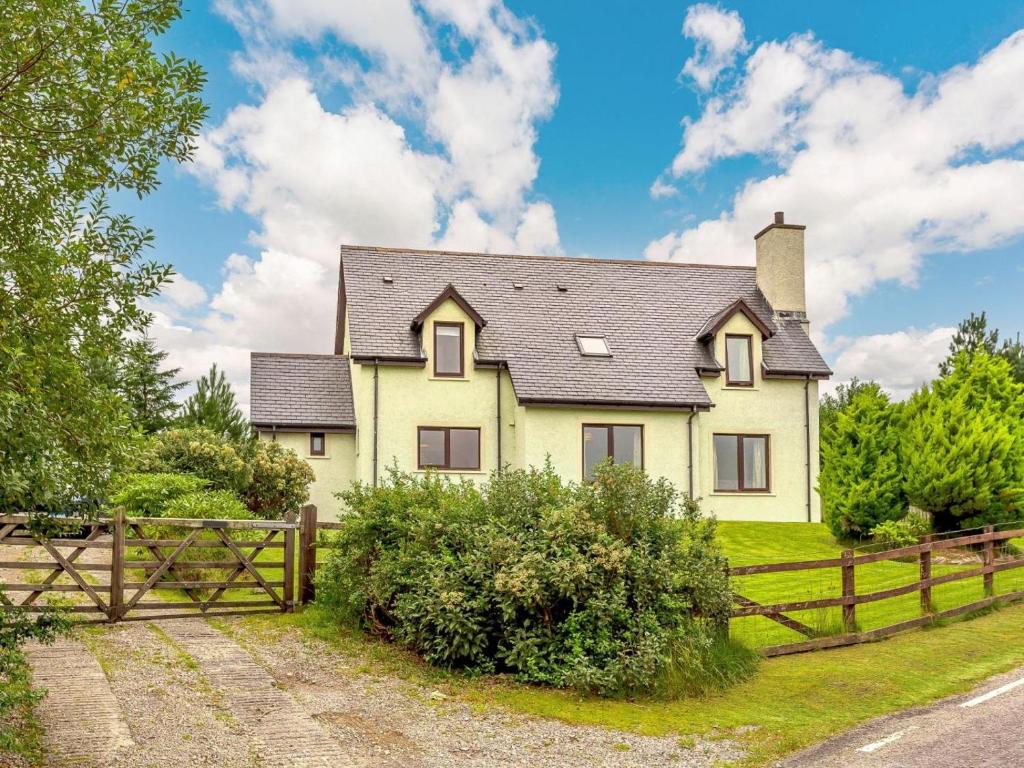 a yellow house with a wooden fence at 4 Bed in Gairloch oc-ca390 in Strath