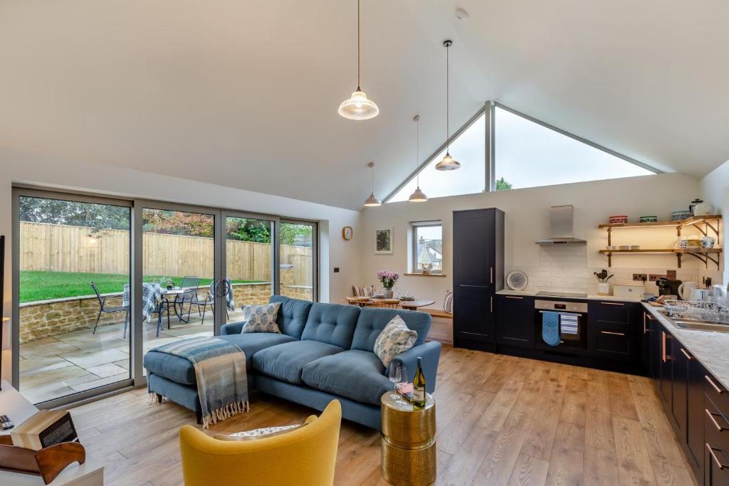 a living room with a blue couch and a kitchen at 2 Bed in Melplash oc-r30043 in Netherbury