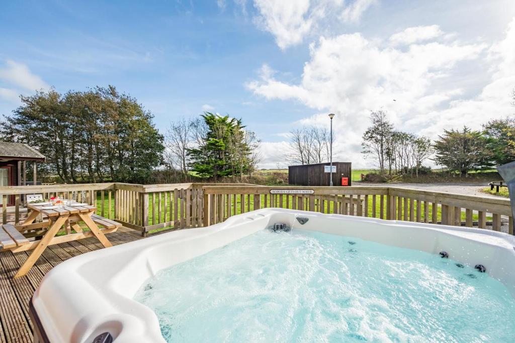 a hot tub on a deck with a wooden fence at 3 Bed in St. Merryn oc-r30137 in Saint Merryn