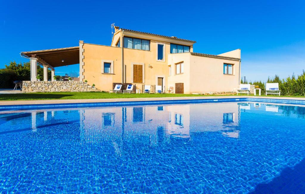 a villa with a swimming pool in front of a house at Finca Llum in Manacor