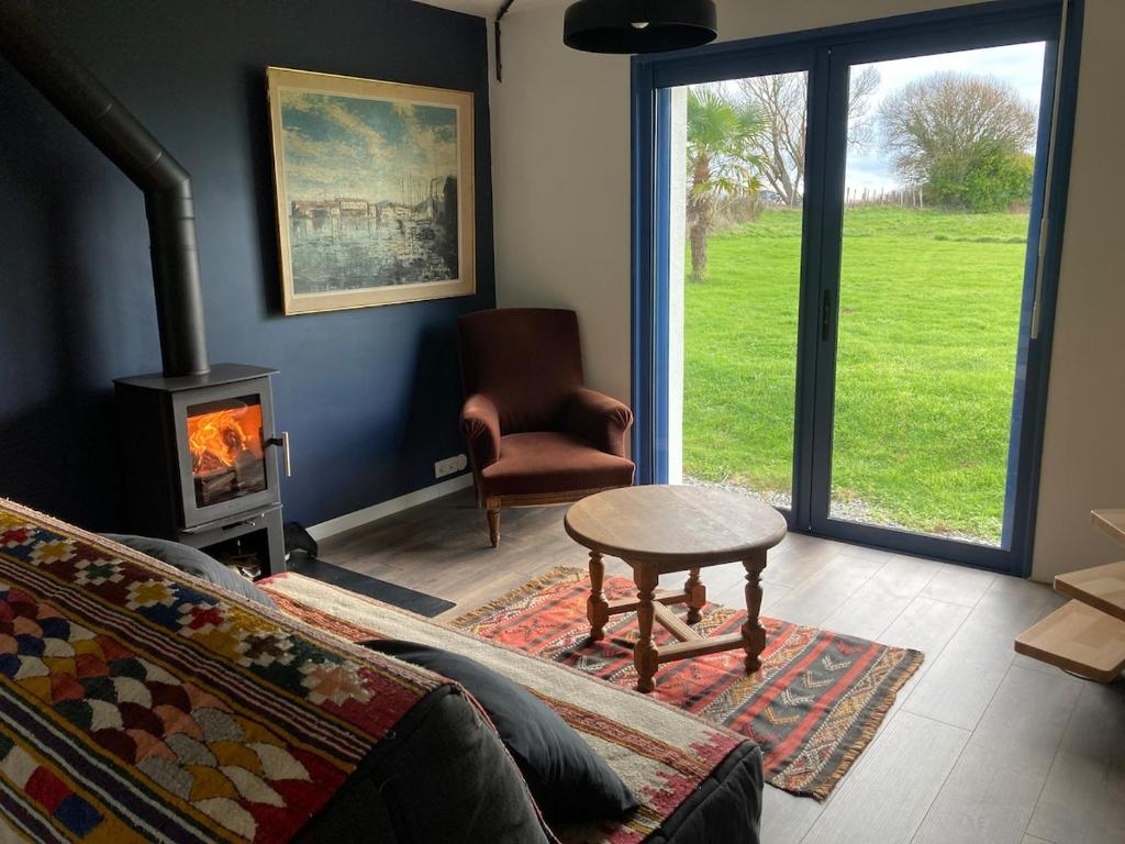 a living room with a couch and a chair and a fireplace at Portec la mer et le sentier côtier à pied in Moëlan-sur-Mer