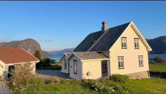 a white house with a black roof next to a building at Oanes House in Forsand