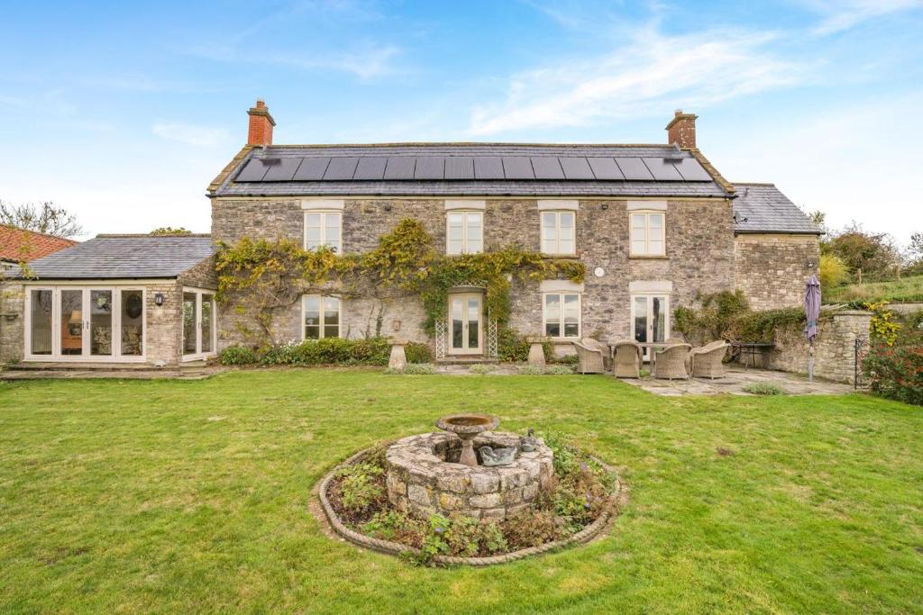 an old stone house with a fountain in the yard at 5 Bed in Bleadney oc-r33959 in Henton