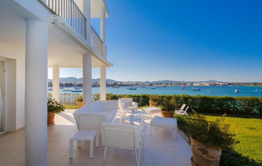 a patio with white furniture and a view of the water at Esperanza in Portocolom