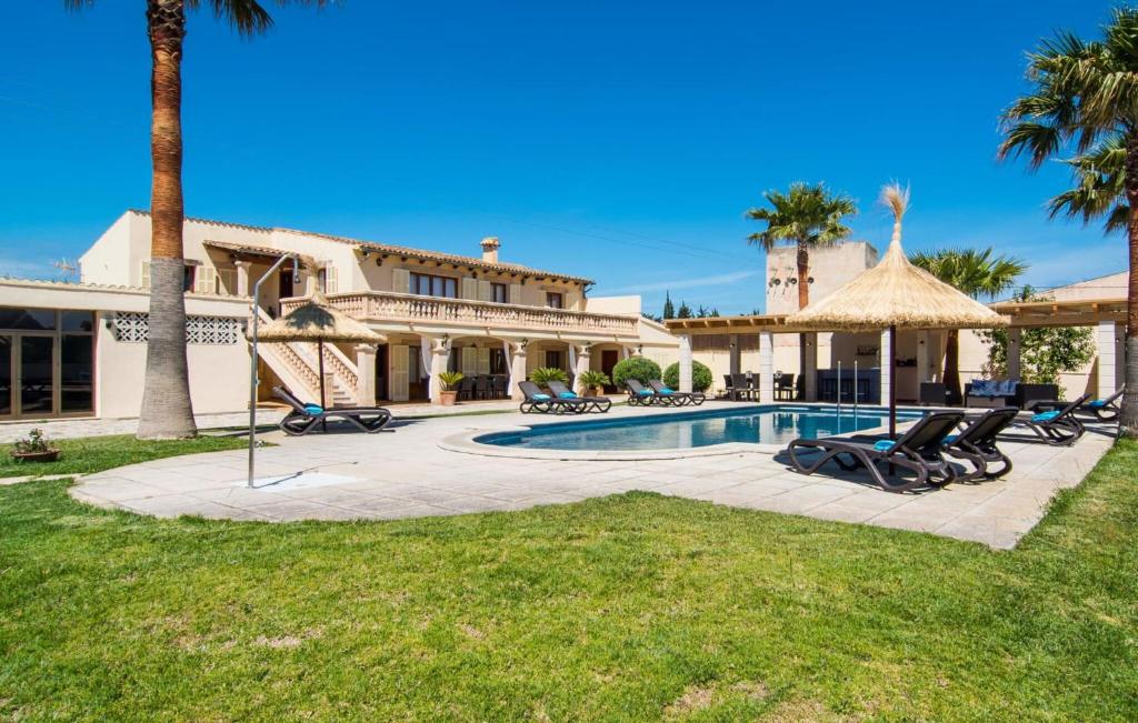 a large house with a swimming pool and palm trees at Catalina in Alcudia