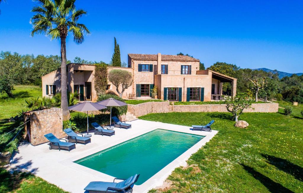 a villa with a swimming pool in front of a house at Esteva in Sant Llorenç des Cardassar