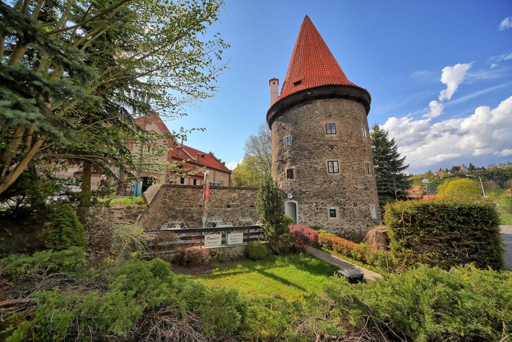 an old building with a tower in the middle of a yard at Krumlov Tower in Český Krumlov