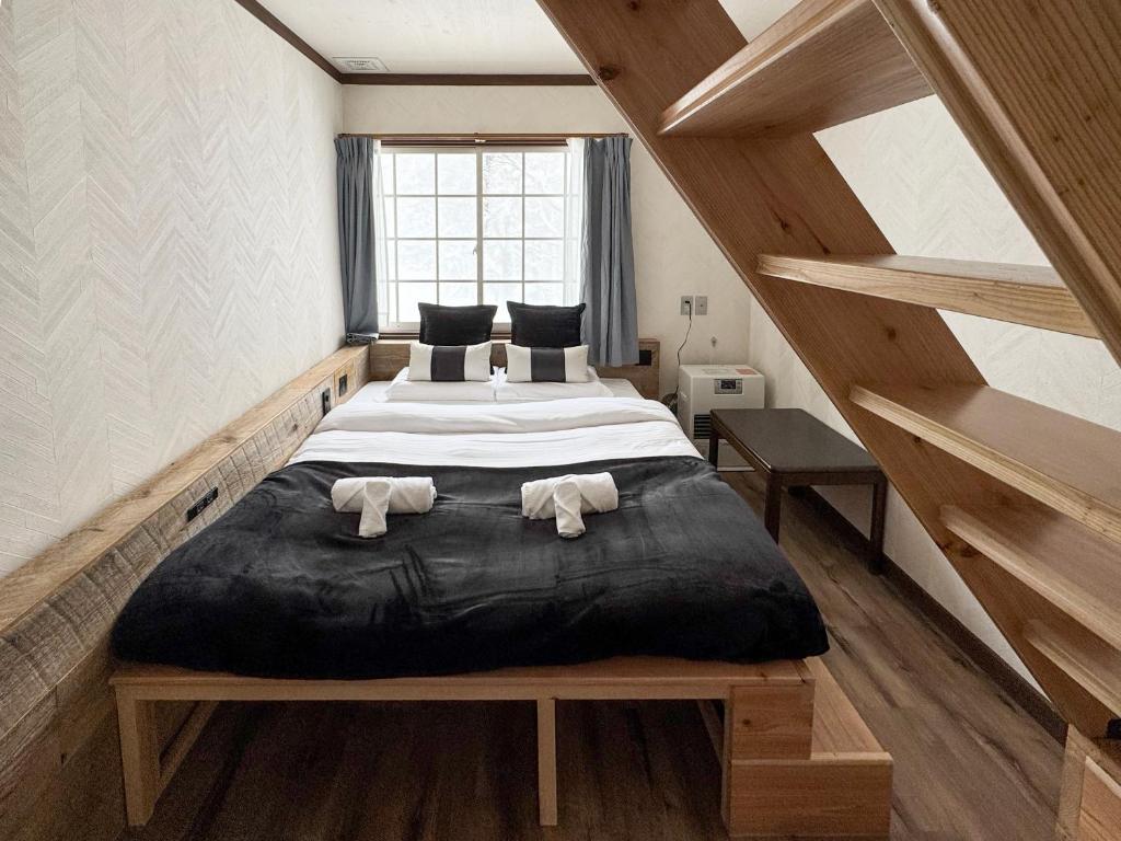 a bedroom with a large bed with towels on it at Apricot Pension in Hakuba