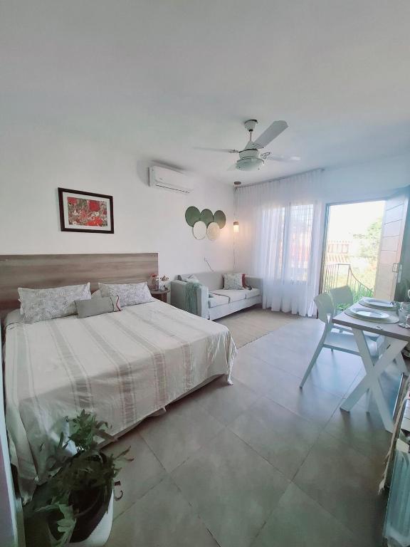 a white bedroom with a bed and a table at Monoambiente luminoso con Jacuzzi Relax y estilo in Córdoba