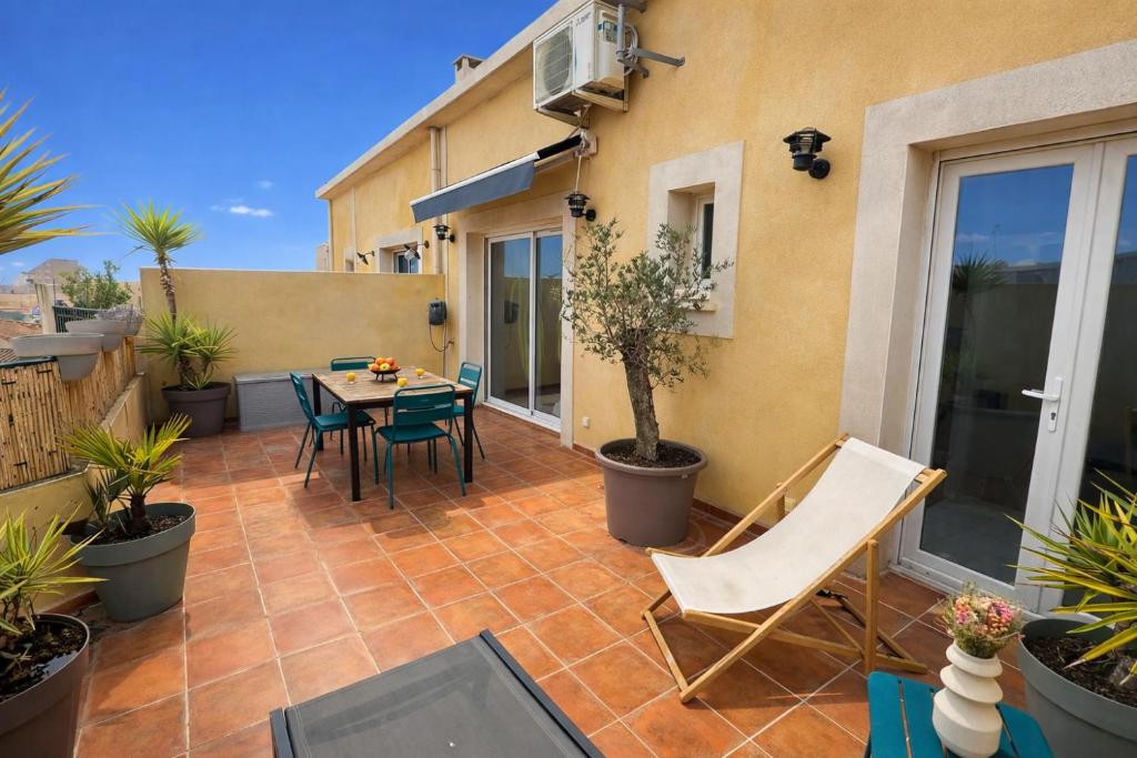 ein Balkon mit Tisch und Stühlen auf einer Terrasse in der Unterkunft Roq duplex in Valras-Plage
