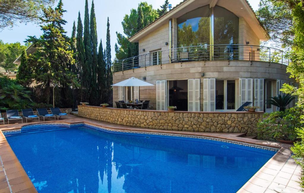 a house with a swimming pool in front of a house at Cocodrilo in Alcudia