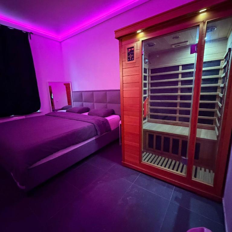 a purple room with a bed and a window at La Suite White wellness Jacuzzi & Sauna in Seraing