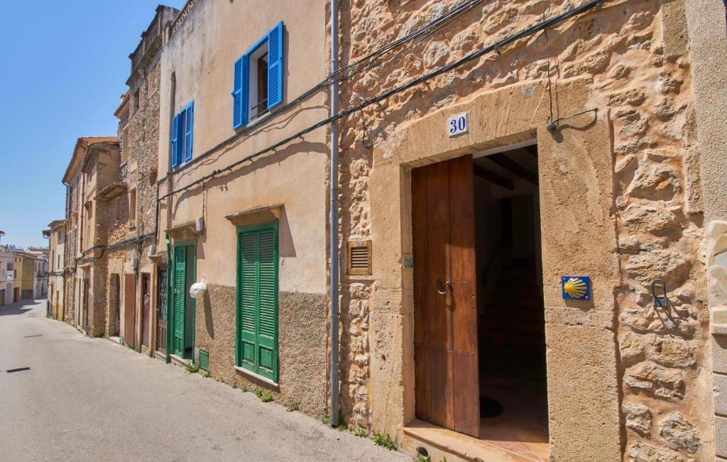 an old stone building with green doors on a street at Maria Angela in Artá