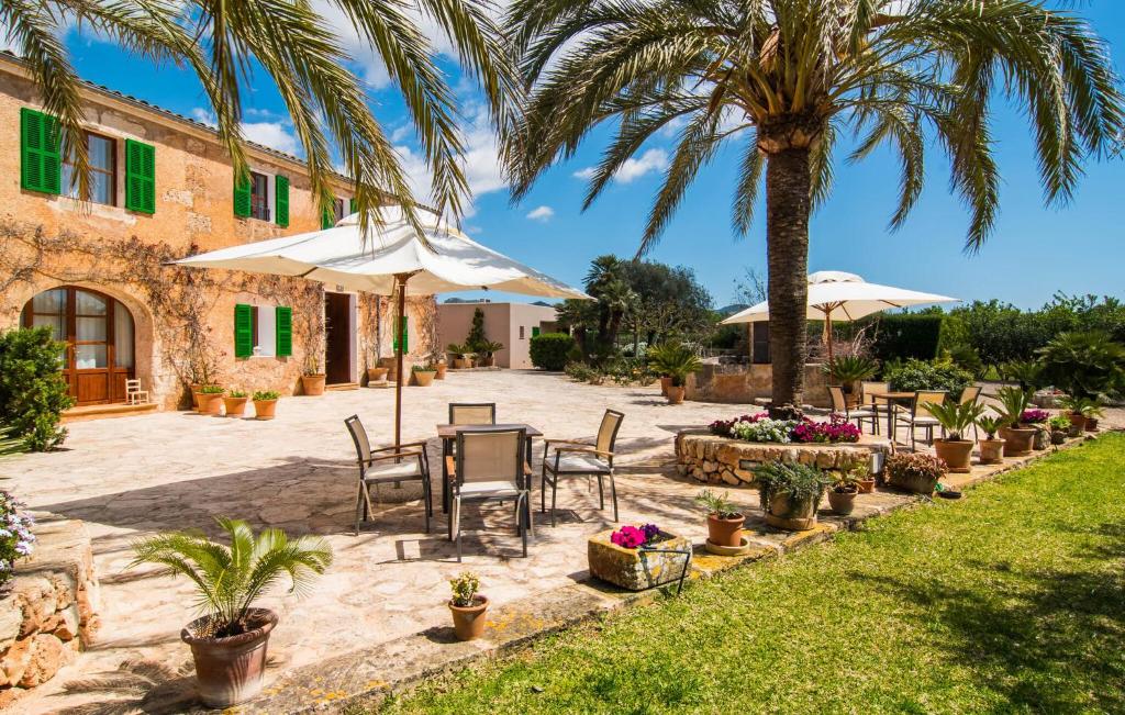 a patio with a table and chairs and palm trees at Son Capellot Cinco in Felanitx