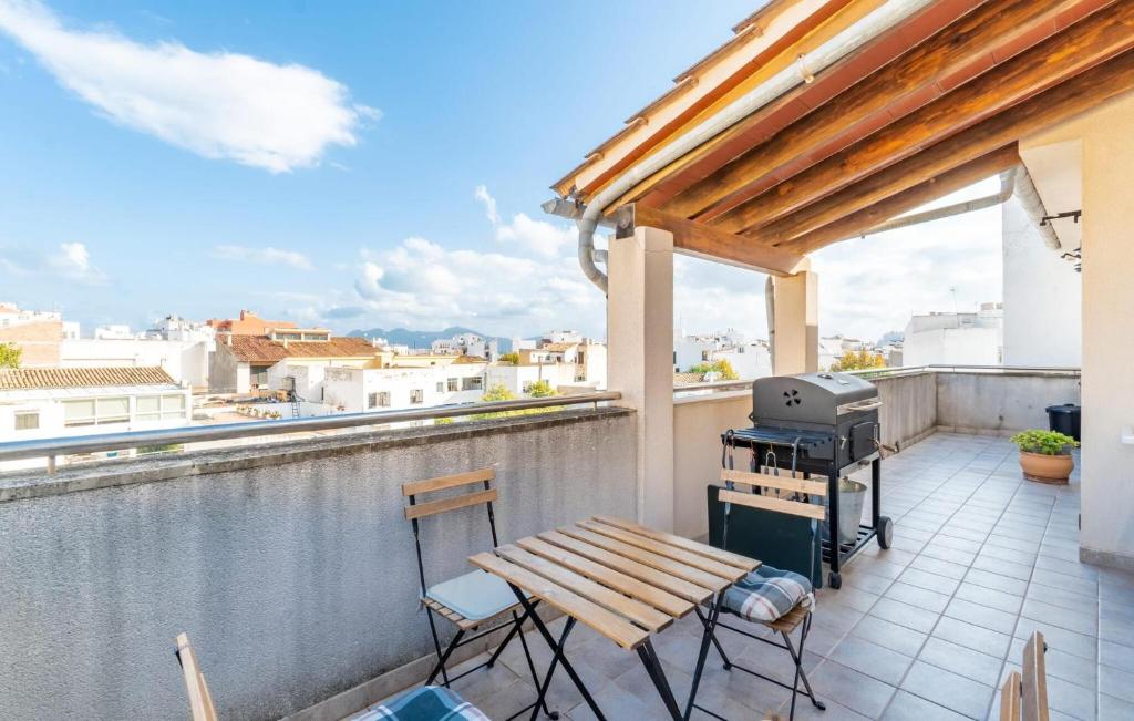 a balcony with a grill and a table and chairs at Atico Roger De Flor in Port de Pollensa